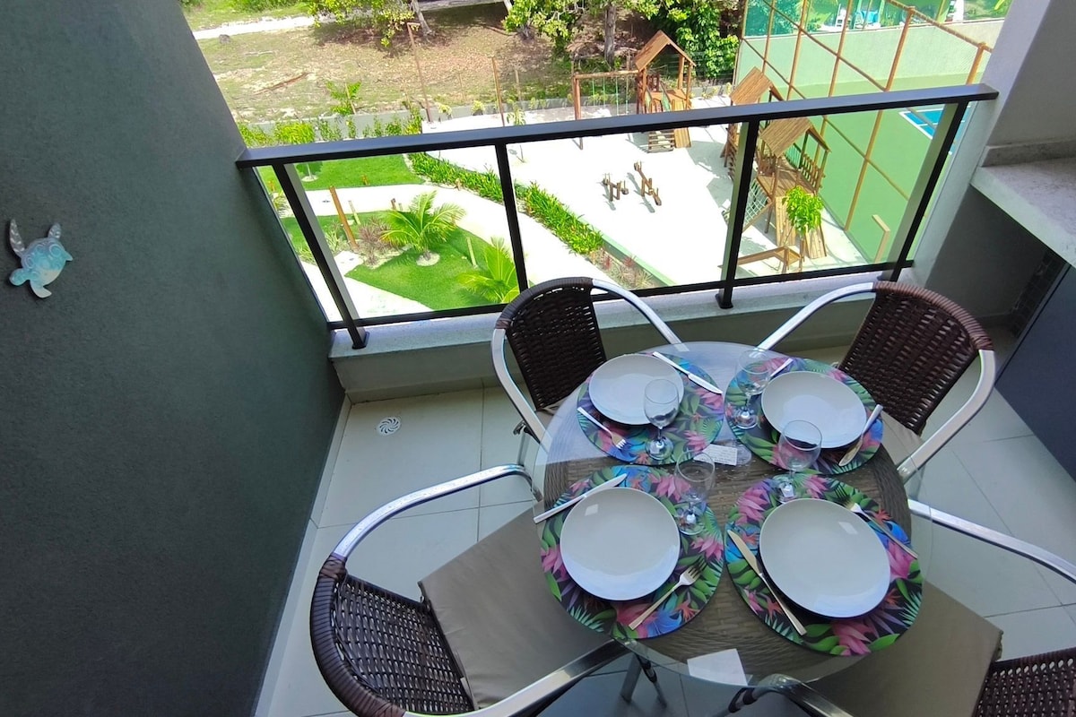 A balcony with a round table set for four, surrounded by wicker chairs.