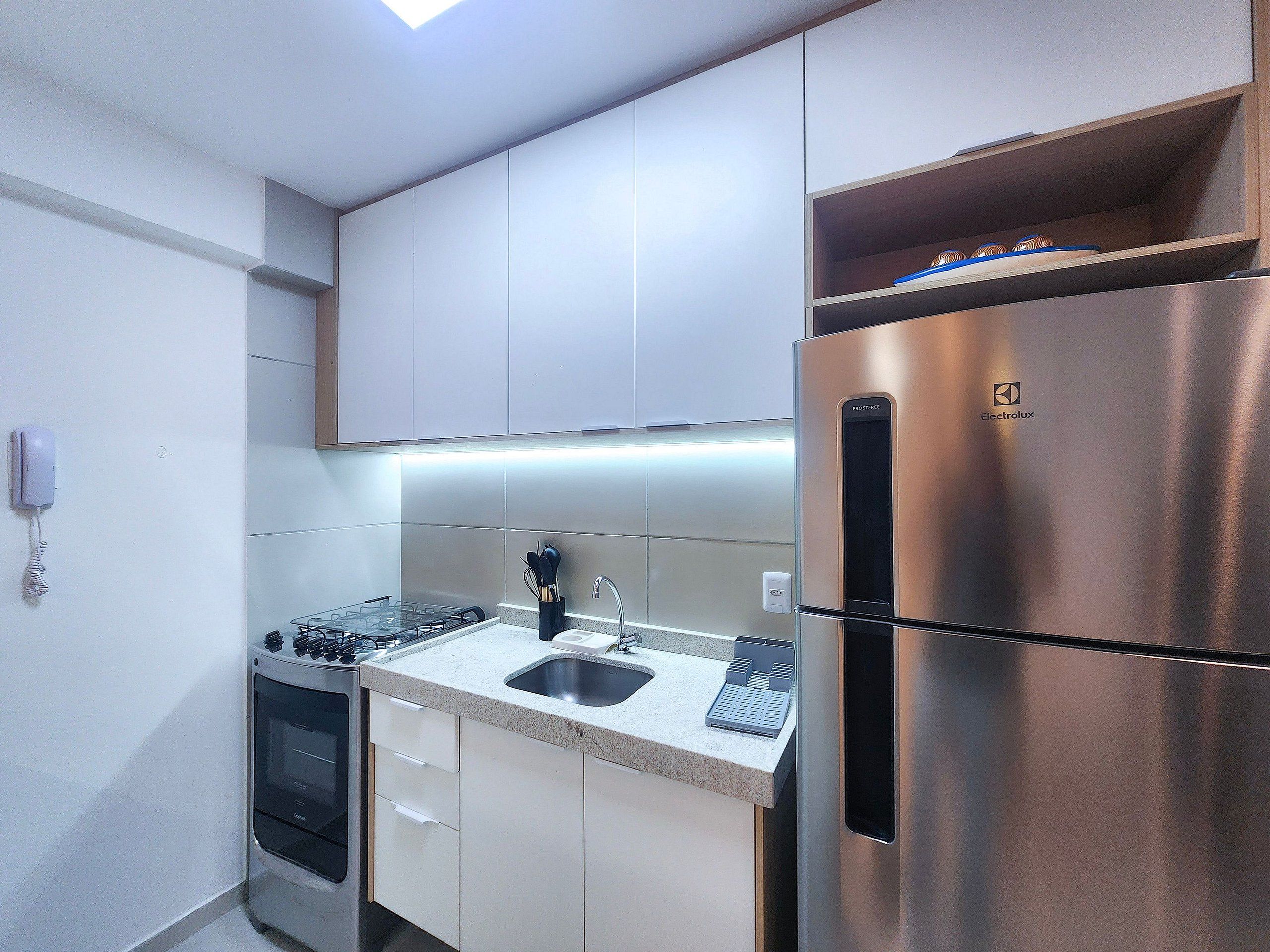 Una cucina moderna con elettrodomestici in acciaio inossidabile, forno integrato e lavello.