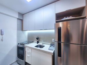 A modern kitchen with stainless steel appliances, a built-in oven, and a sink. - Galapagos Beach Residence - Praia dos Carneiros (Tamandaré)