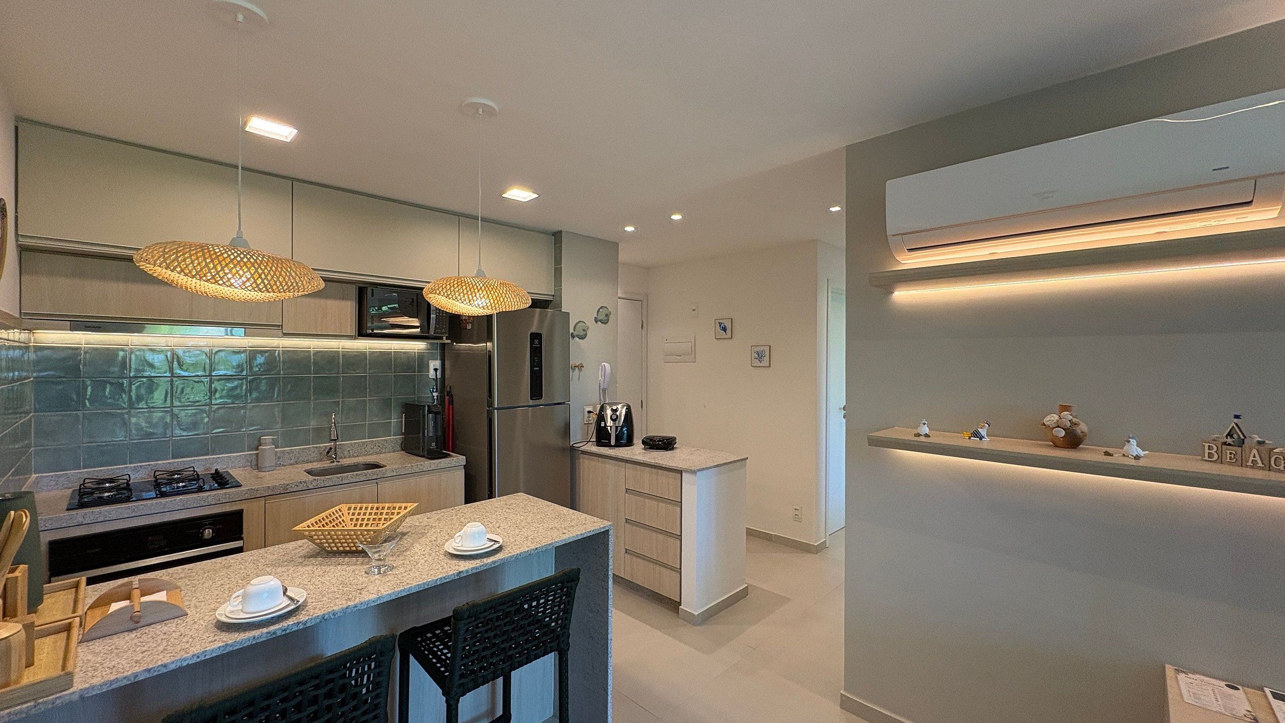 A modern kitchen with a central island, stainless steel appliances, and pendant lighting.