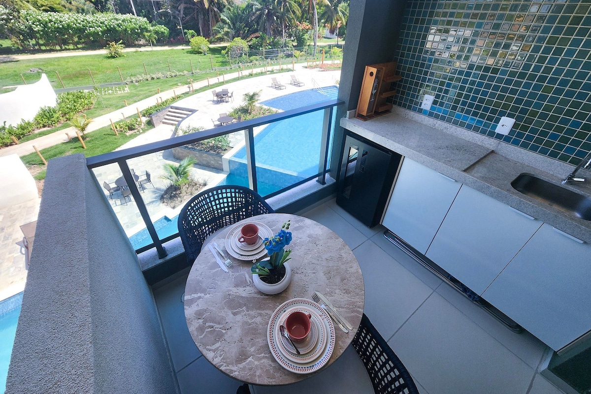 A balcony with a view of a swimming pool, a dining table set with plates and cutlery, and a potted plant.