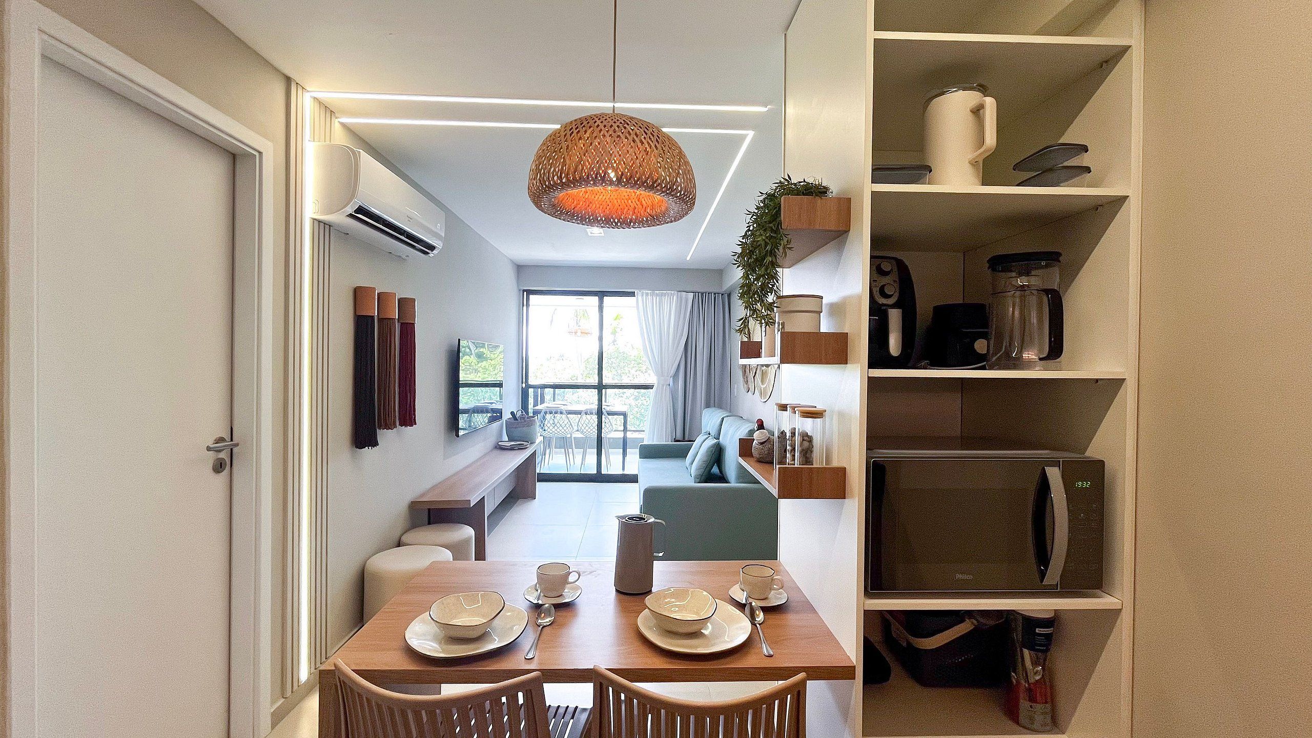 A modern interior with a dining area, a sofa, and a kitchen area with a microwave.