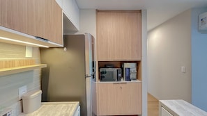 A compact kitchen with a microwave, coffee maker, and a small refrigerator. - Galapagos Beach Residence - Praia dos Carneiros (Tamandaré)