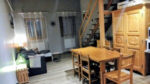 Una cocina compacta con armarios de madera, una mesa de comedor y sillas.