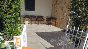 A gated entrance with a stone wall and a potted plant. - Adonai House (Sicilia)