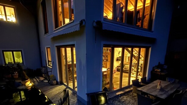 Un bâtiment à deux étages doté de grandes fenêtres et d’un espace extérieur abrité.