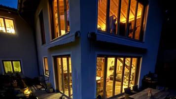 Un bâtiment à deux étages doté de grandes fenêtres et d’un espace extérieur abrité.