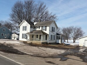 A two-story house with a porch, a garage, and a detached garage. - 3 bedroom 2 car garage near Lake Erie and cedar point great for large groups (Clyde)