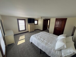 A bedroom with a bed, dresser, and a television on the wall. - 3 bedroom 2 car garage near Lake Erie and cedar point great for large groups (Clyde)