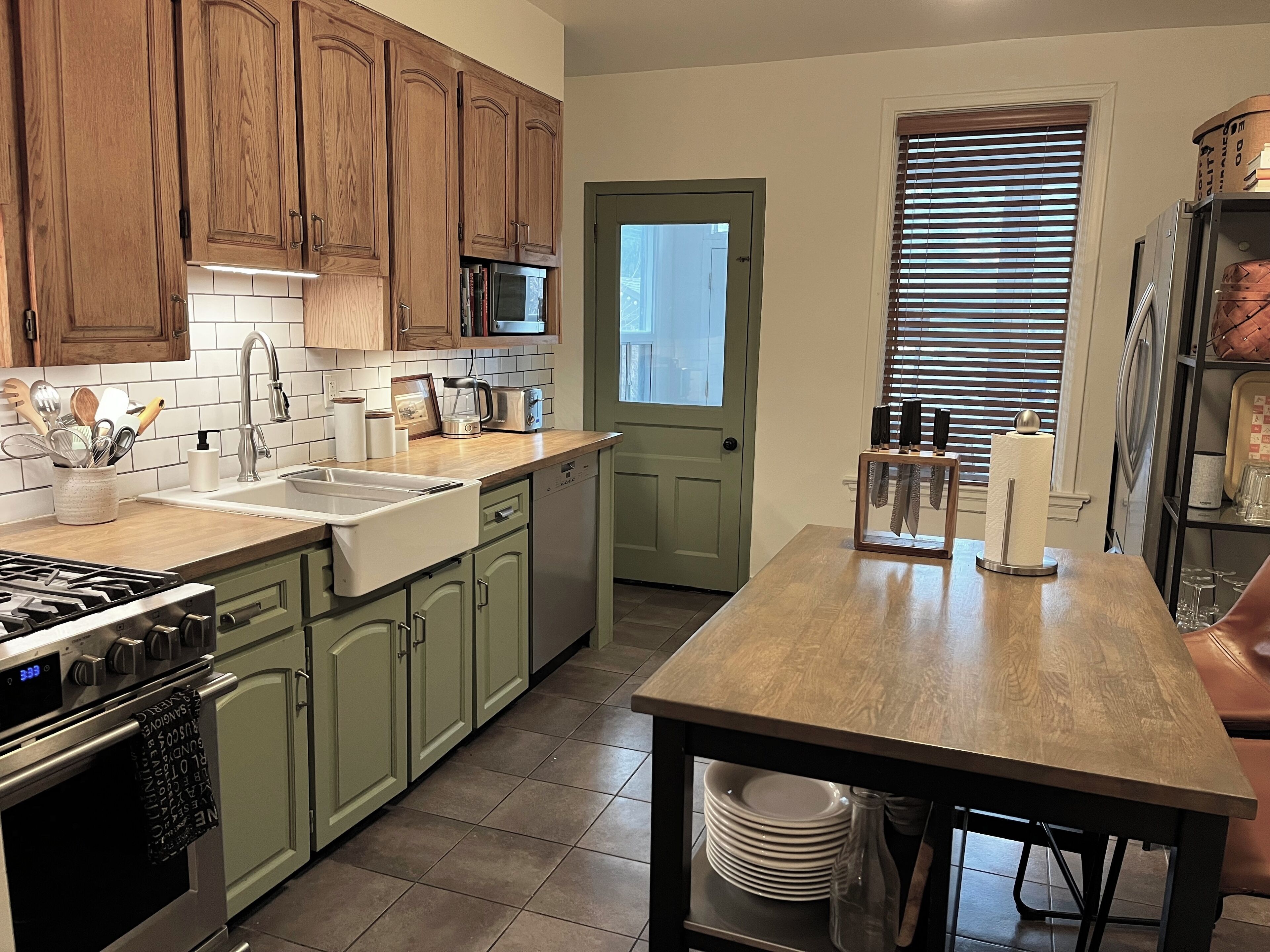 A kitchen with wooden cabinets, a microwave, a sink, and a stove.