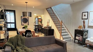 A modern living room with a grey sofa, wooden coffee table, and a staircase. - Trendy Roncesvalles Village. Just steps to shopping, dining, Lake Ontario (Toronto)