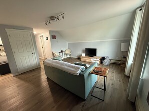 A living room with a sofa, TV, wooden coffee table, and a TV stand.