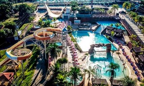 A water park with a large pool, slides, and a wave machine.
