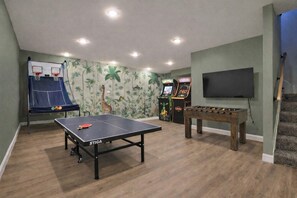 A room with a ping pong table, a foosball table, and arcade games. - Pool | Hot Tub | Pickleball | Firepit (Williamstown)