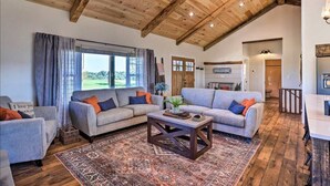 A spacious living area with a high wooden ceiling, a large window with curtains, a fireplace, and a 'WELCOME' sign. - Pool | Hot Tub | Pickleball | Firepit (Williamstown)
