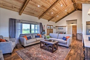 A spacious living area with a high wooden ceiling, a large window with curtains, a fireplace, and a 'WELCOME' sign. - Pool | Hot Tub | Pickleball | Firepit (Williamstown)