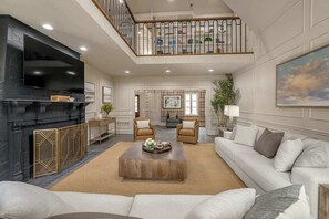 A spacious living area with a fireplace, a television, and a comfortable seating arrangement.