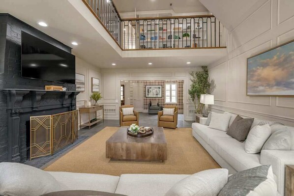 A spacious living area with a fireplace, a television, and a comfortable seating arrangement.