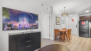 A modern kitchen with a refrigerator, wooden dining table, and chairs. - Orlando Comfort Close to Top Universal's Attractions (Orlando)