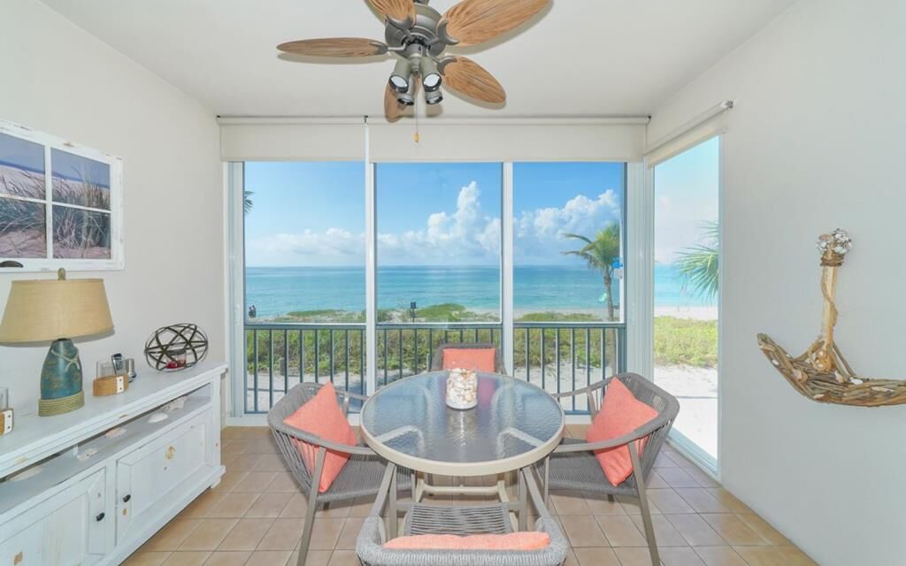 A dining area with a round table, chairs, and a ceiling fan.