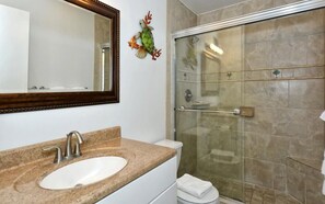 Une salle de bain avec un lavabo, un miroir et une douche.