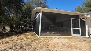 Een modern huis met een ruime overdekte patio, een schuifpui en een schoorsteen.