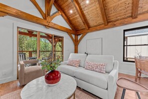 A room with a white sofa, a red vase, and a wooden ceiling. - Ruby Cabin at Highland Peaks Retreat (Highlands)