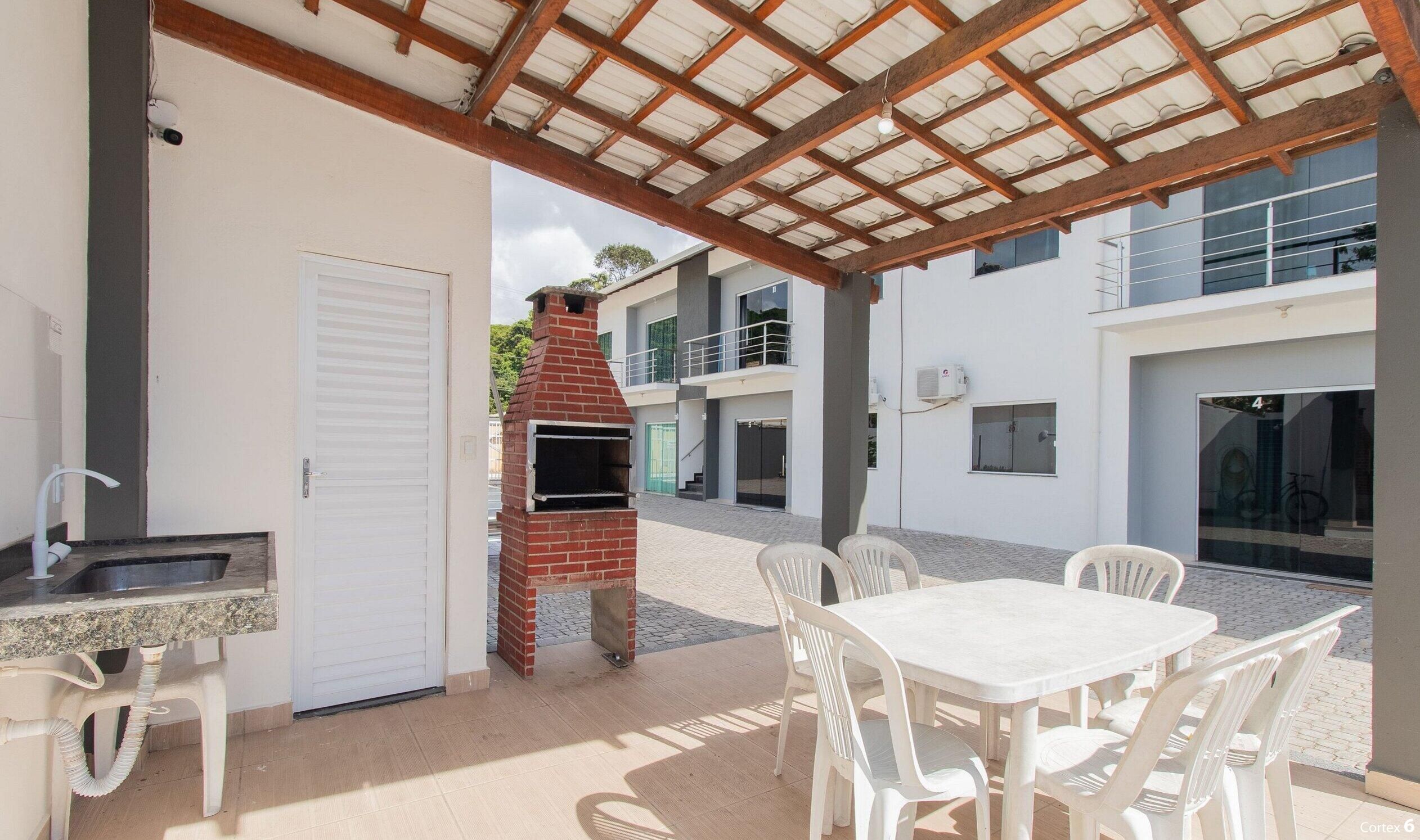 A patio with a brick oven, outdoor seating, and a covered area.