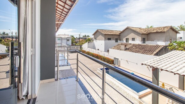 A modern hotel with a swimming pool, a covered outdoor area, and a view of neighboring buildings. - Apts in Condominium w/ Pool and Barbecue - Ctys (Porto Seguro)