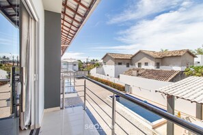 A modern hotel with a swimming pool, a covered outdoor area, and a view of neighboring buildings. - Apts in Condominium w/ Pool and Barbecue - Ctys (Porto Seguro)