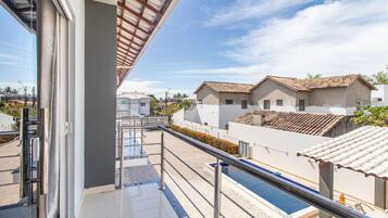 Un hotel moderno con piscina, un espacio exterior cubierto y vistas a edificios vecinos.