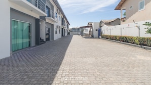 A paved pathway between buildings with a clear sky. - Apts in Condominium w/ Pool and Barbecue - Ctys (Porto Seguro)