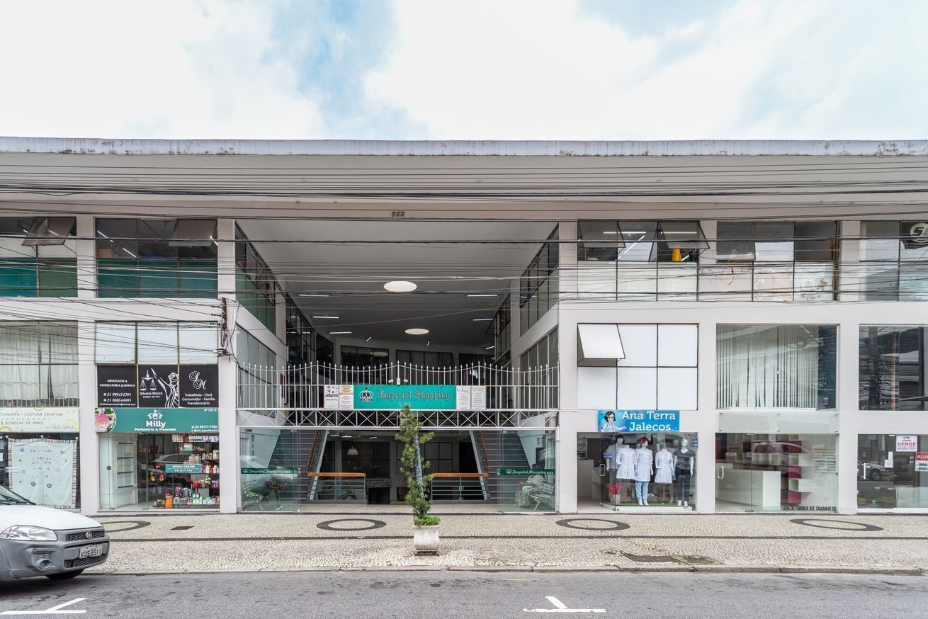 A modern building with a covered entrance, a sign for 'Ana Terra Jaleos', and a 'Milly' store.
