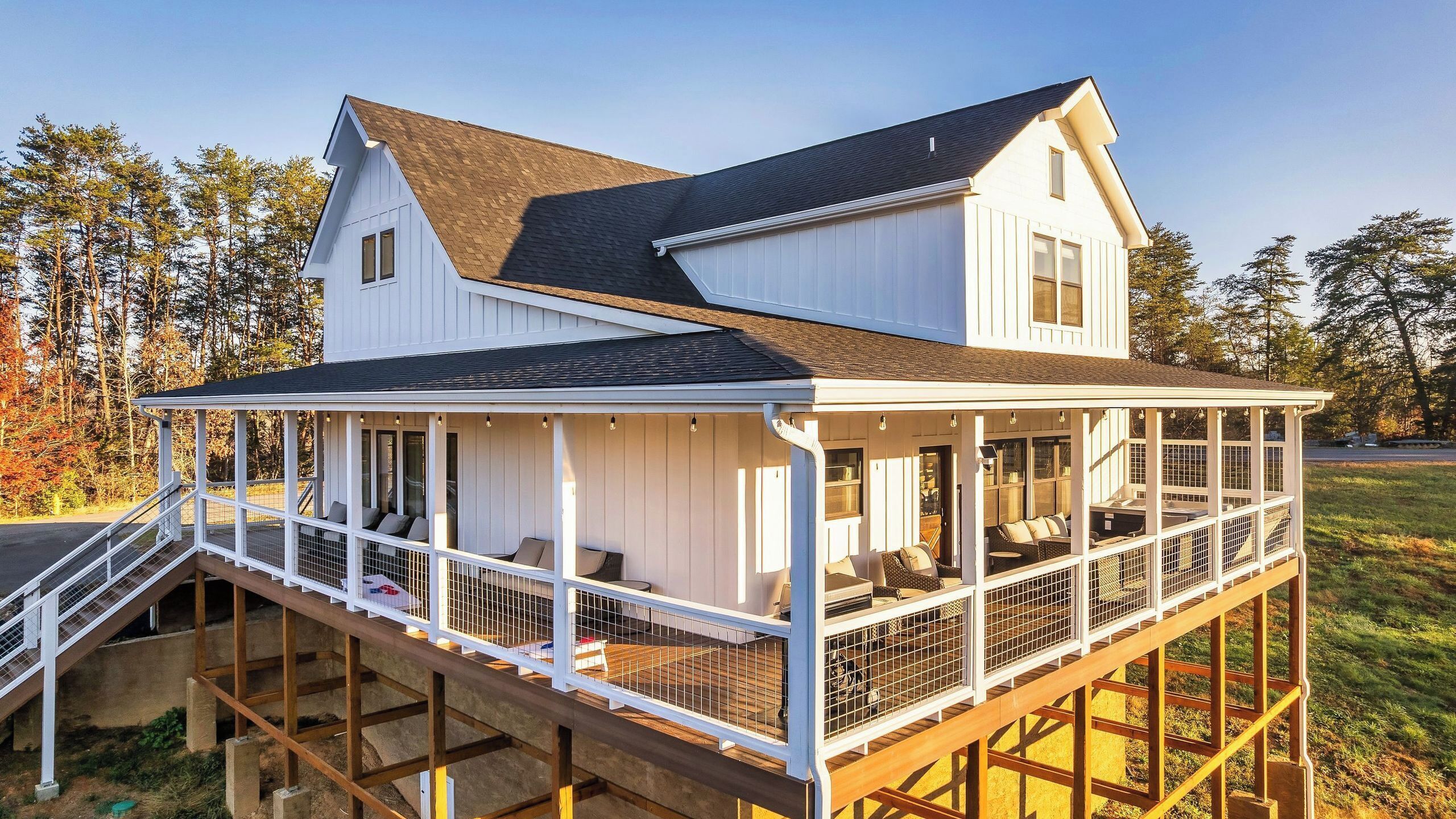 A two-story house with a covered porch and a deck.