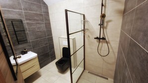 Une salle de bain moderne équipée d’une douche, de toilettes et d’un lavabo.