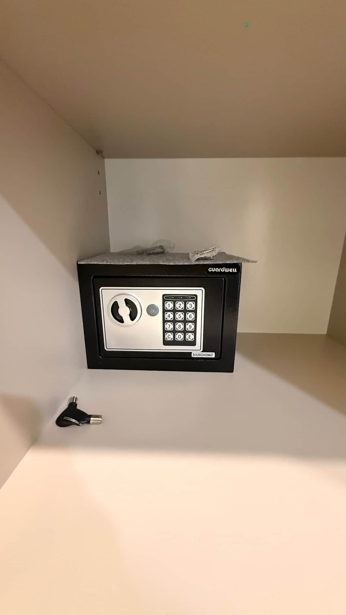 A black security keypad with a numeric keypad and a keyhole, labeled 'Guardwell'.