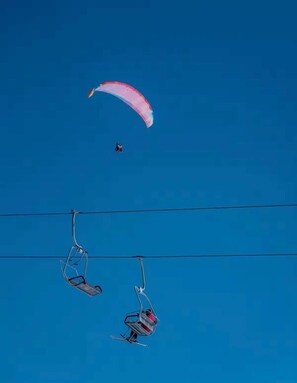 A clear blue sky with a paraglider and two ski lifts against it. - Altimera Collection - Stem - Ski-In/Ski-Out (Dusheti Municipality)