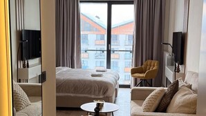 Een moderne hotelkamer met een groot bed, een bank, een salontafel en een televisie.