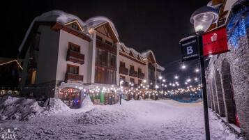 En snötäckt gata med byggnader och en skylt för hotellet ”B”.