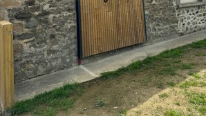 Um edifício de pedra com uma porta de madeira com a placa 'Gite Lyloni'.