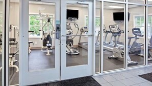 A fitness center with cardio machines, weight machines, and a treadmill.
