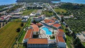 An aerial view of a resort with a swimming pool, multiple buildings, and a view of the sea. - Niriides Hotel (Rhodes)