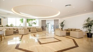 A spacious lobby with a polished marble floor, multiple seating areas, and large windows allowing natural light. - Niriides Hotel (Rhodes)