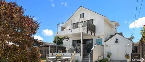 A two-story house with a balcony, a garage, and a patio area.
