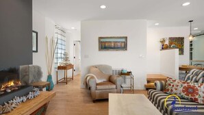 A living room with a fireplace, a sofa, and a coffee table. - Beachcrest Cottage in Twin Lakes Beach (Santa Cruz)