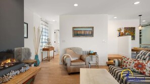 A living room with a fireplace, a sofa, and a coffee table. - Beachcrest Cottage in Twin Lakes Beach (Santa Cruz)