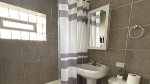 A bathroom with a bathtub, sink, toilet, and a window with a view. - Ravenswood Loft - Peaceful 2-bedroom apartment in vibrant Chicago (Chicago)