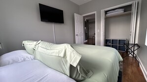 A bedroom with a bed, a TV mounted on the wall, and an open closet. - Ravenswood Loft - Peaceful 2-bedroom apartment in vibrant Chicago (Chicago)