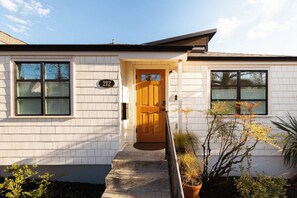 A single-story house with a white exterior, a wooden front door, and a mailbox. - NEW Seattle Retro Retreat | Walk to Shops & Coffee (Seattle)