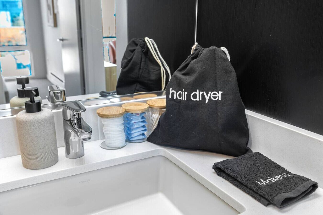 Een badkamer met een wastafel, een föhnzak en een handdoek.